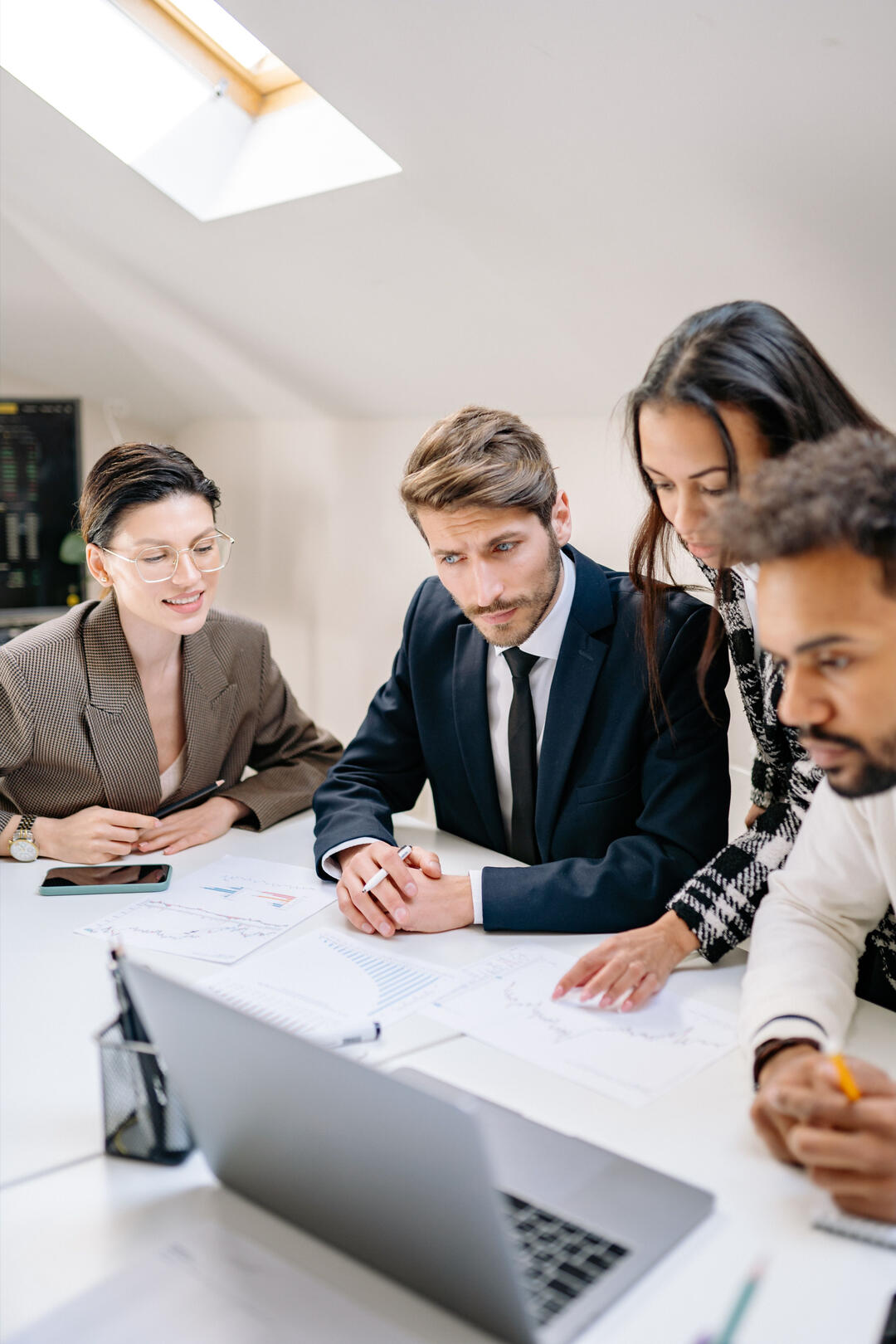 Diverse team of financial professionals reviewing charts and reports together